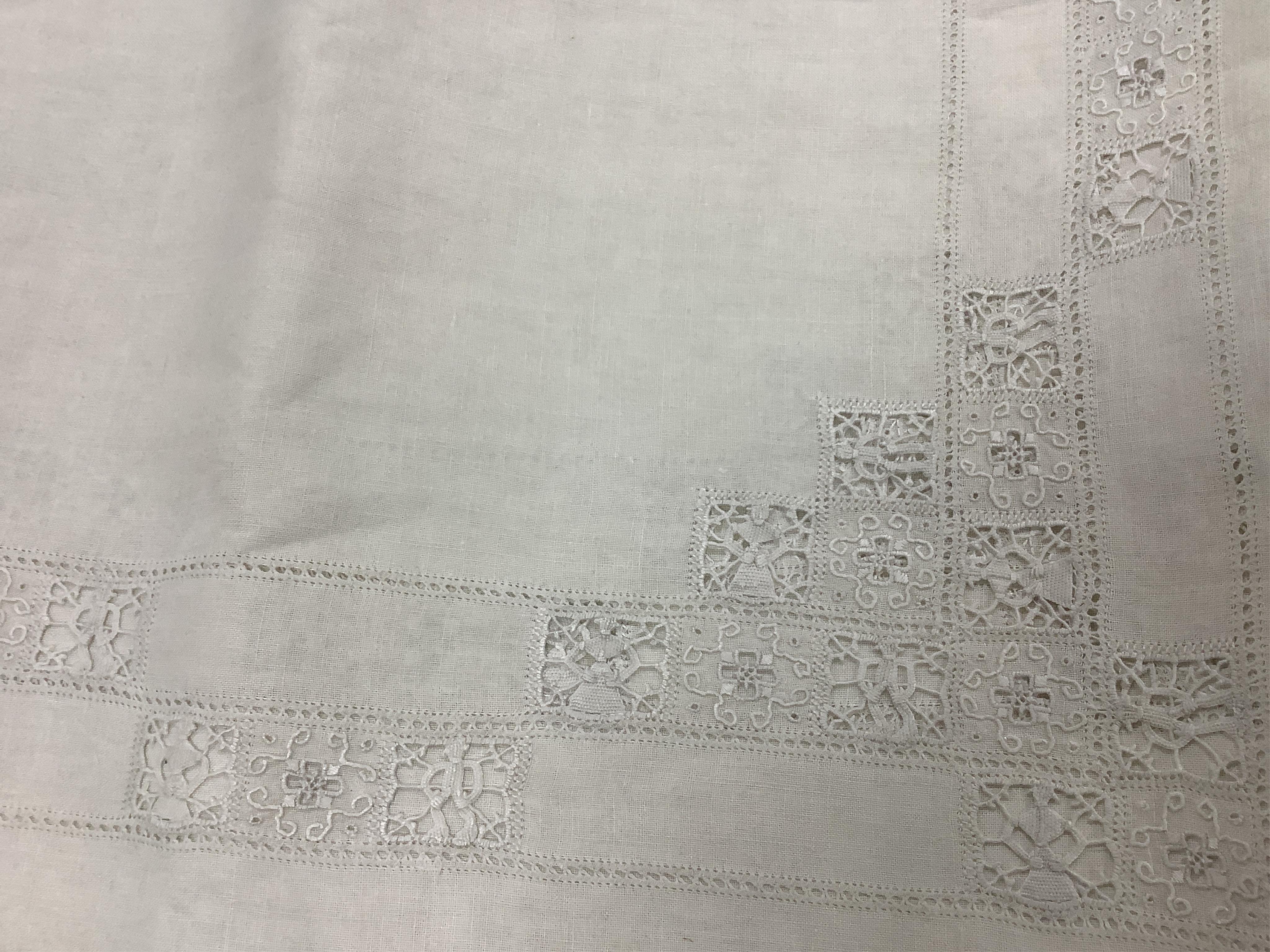An Italian large linen drawn thread worked and embroidered table cloth, with small square needle lace insertions, 275cm long x 180cm wide. Condition - has a rust line, which maybe removed with rust remover. The cloth is
